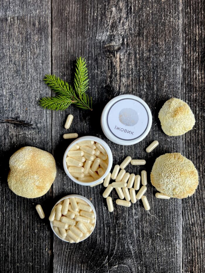 Натуральні капсули їжовика гребінчастого біля цілого гриба, мінімалістичне фото