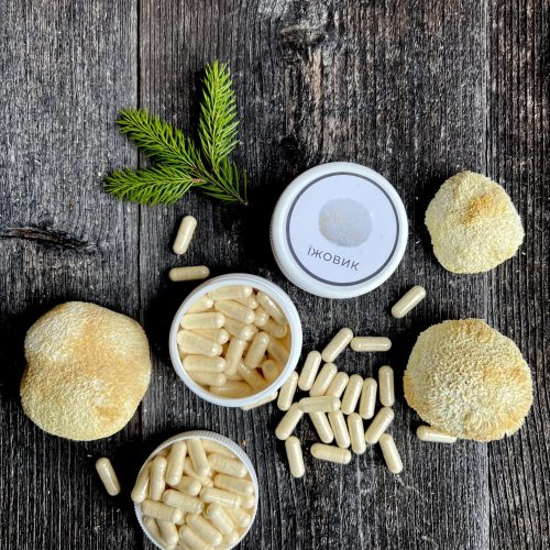 Натуральні капсули їжовика гребінчастого біля цілого гриба, мінімалістичне фото